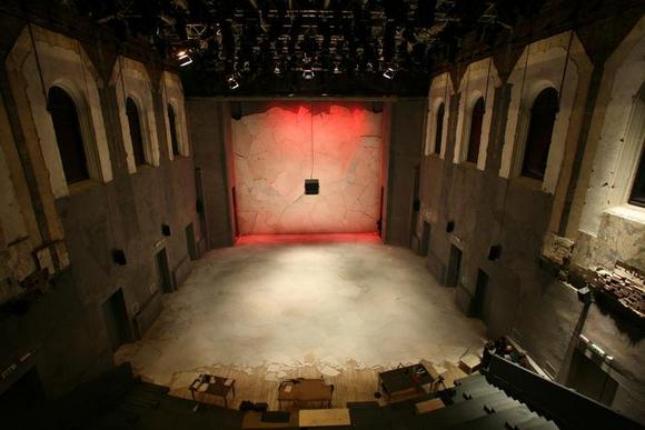 La sala del Teatro Astra con la scenografia di Atti di guerra, firmata da Tiziano Santi