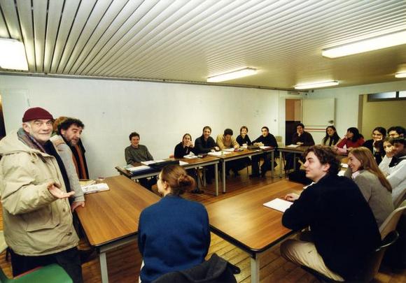 Massimo Castri, direttore del TST in visita alla compagnia durante le prove a tavolino di Visita dell'uomo grigio (2000/01). Da sinistra, in senso orario: Massimo Castri, Mauro Avogadro, Marco Albertano, Francesca Piccozza, Alessandro Adriano, Fabio Troiano, Giulia Troiano, Sax Nicosia, Luca Levi, Alessia Bellotto, Chiara Scorrano, Carlotta Viscovo, Alessio Romano, Alessia Giangiuliani, Carmelo Rifici, Giorgia Porchetti, Gultiero Burzi, Thea Della Valle