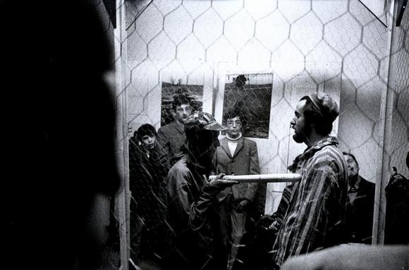 Nella stanza "prigione" un performer-guardia armata di manganello affronta un performer-internato