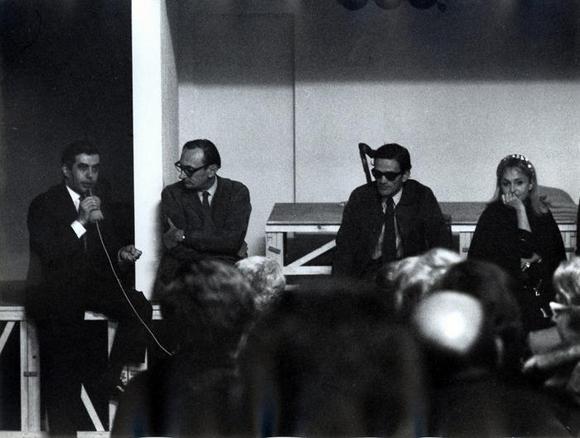 Da sinistra, al microfono Nuccio Messina, Gian Renzo Morteo, Pier Paolo Pasolini, Laura Betti, durante un dibattito col pubblico al Deposito d'arte presente